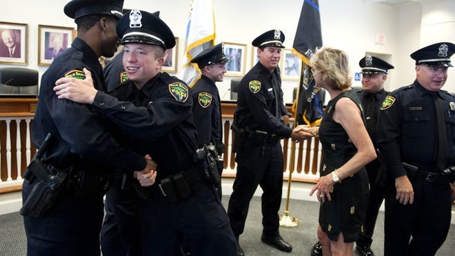 New Palm Beach Police officers Anducchi Augustin, from left, Justin Rothenburg, Jake Lampiasi, Matt DeWalt, Gabriel DaSilva and Christopher Barber shake hands with Mayor Gail Coniglio after a ceremonial swearing-in during an award ceremony Thursday April 26, 2018 at Town Hall in Palm Beach. (Meghan McCarthy / Daily News)