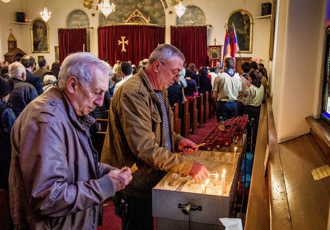 People light candles in commemoration of the the Armenian Genocide during a ceremony at Saints Sahag and Mesrob Church in Providence on Sunday. [The Providence Journal / David DelPoio]
