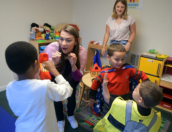 Volunteer Crystaltina Montagna plays "super heroes" with, from left, Shakir, 6, Aden, 5, and Austin, 4, in the Playspace Program room at Horizons for Homeless Children in Worcester. Volunteer Kelly Zdanuczyk is in the background. [T&G Staff/Allan Jung]