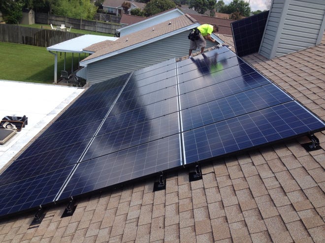 An employee with Pensacola-based Compass Solar installs solar panels on a Gulf Breeze home. The company has expanded its operations into Bay County. [CONTRIBUTED PHOTO]