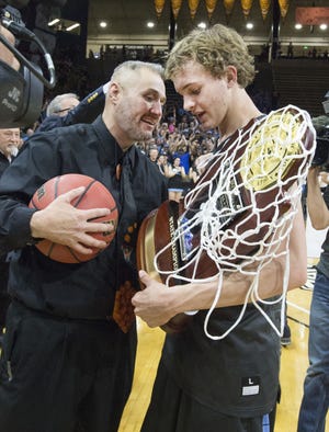 Pueblo West's Kenny Tack, right, gets ready to hand the championship trophy to head coach Bobby Tyler after West defeated Valor Christian to win the 4A state high school basketball championship at the Coors Events Center in Boulder, Colo. (Chris McLean, The Pueblo Chieftain)
