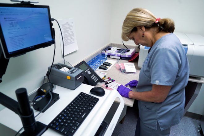 FILE - In this Aug. 7, 2017, file photo, Stephanie Richurk, a nurse at the University of Pittsburgh Medical Center, sorts blood samples collected from participants in the "All of Us" research program in Pittsburgh. The National Institutes of Health announced on Tuesday, May 1, 2018, that it will open nationwide enrollment and is seeking 1 million volunteers to share their DNA and medical records. (AP Photo/Dake Kang, File)