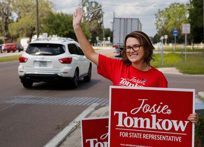 Josie Tomkow, candidate for Florida State Representative Seat 39, waves to passing motorists as she campaigns near the voting place at the Donald Bronson Community Center in Polk City on Tuesday.