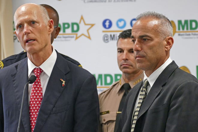 Florida Gov. Rick Scott, left, talks alongside Andrew Pollack, whose daughter Meadow was murdered in Parkland, and Miami-Dade County mayor Carlos A. Gimenez, during a news conference at Miami-Dade Police Department in Doral, Fla., on Tuesday, Feb. 27, 2018. Pollack has filed a wrongful death lawsuit against former Broward Sheriff Deputy Scot Peterson, gunman Nikolas Cruz and several others.