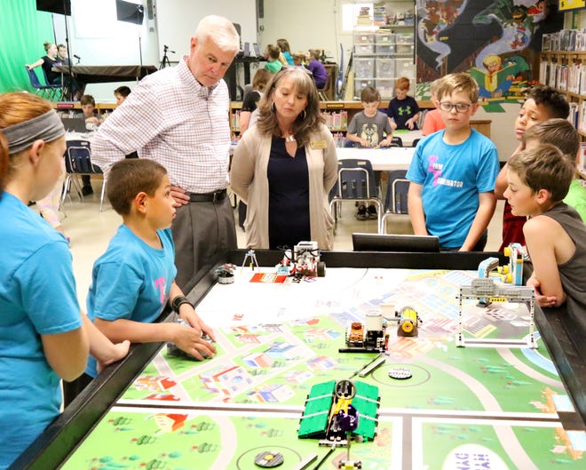 During a visit to Hackett Elementary School on Monday, April 30, 2018, Congressman Steve Womack and elementary pPrincipal Tura Bailey listen to members of the school's Team Terminator explain the concept of the First Lego League and the team's participation in the competition in Springdale and the state meet in Fayetteville at the UA campus. First Lego League teams research a real-world problem such as food safety, recycling, energy and are challenged to develop a solution. The team also must design, build and program a robot using LEGO Mindstorms technology, then compete on a table-top playing field. [JAMIE MITCHELL/TIMES RECORD]