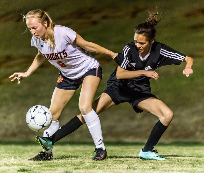 Ledford's Melissa Mickey (right) attempts to sneak the ball away from North Davidson's Makayla Winter during their game Wednesday night at North Davidson. [Dan Busey/The Dispatch]