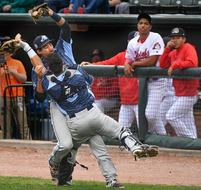 RON JOHNSON/JOURNAL STAR Jordan Pearce, first baseman for the West Michigan Whitecaps, collides with catcher Brady Policelli after making the catch on a pop up for the out during Thursday's Midwest League game with the Peoria Chiefs at Dozer Park.