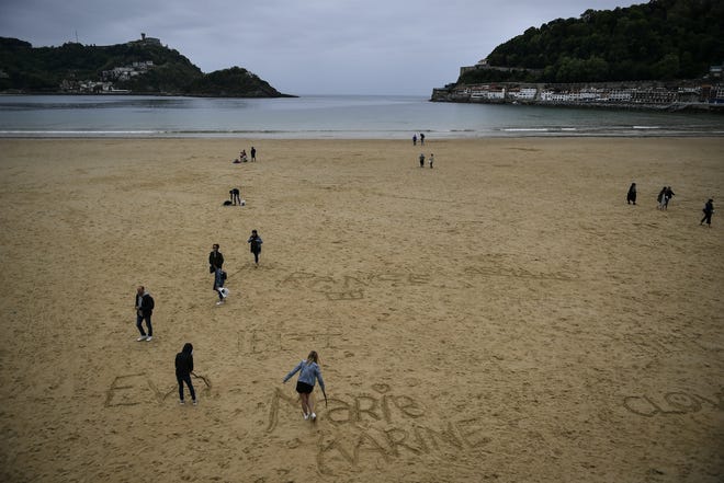 People walk along the sand at La Concha beach, in the Basque city of San Sebastian, northern Spain, Wednesday, May 2, 2018. (Alvaro Barrientos)