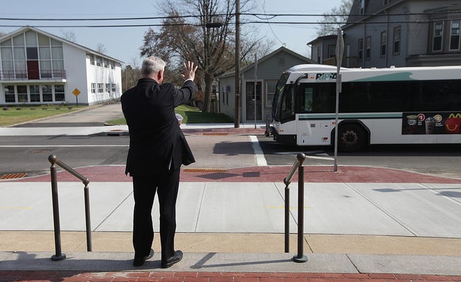 Warwick Mayor Scott Avedisian waves to a RIPTA bus passing Warwick CIty Hall on Thursday. Avedesian will soon begin his new job as CEO of RIPTA. [The Providence Journal / Glenn Osmundson]