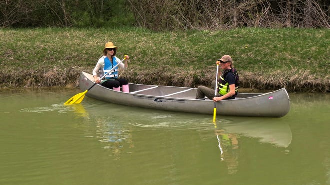 Ashley Weaver, left, and Theresa Clark demonstrate the wrong way to paddle a tandem canoe. It tends to work better when both paddlers face in the same direction and paddle on opposite sides of the canoe.