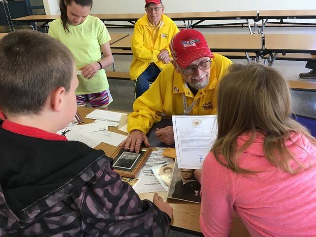 Navy veteran Robert Patterson, of Madrid, shows students letters he recieved before the trip to Washington D.C. and photos of himself while enlisted in the Navy. Photo by Gena Johnson/News-Republican