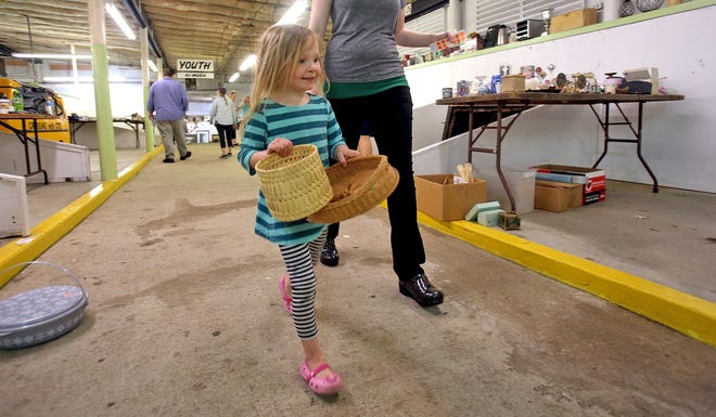 Catherine McDaniel, 4, delivers baskets to be sold at the Attic Treasures Sale at the Cleveland County Fairgrounds on Thursday. The sale is hosted by Junior Charity League and will take place today from 8 a.m. to noon. [Brittany Randolph/The Star]