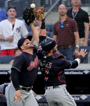 Indians first baseman Yonder Alonso, left, and catcher Yan Gomes collide while trying to catch a pop foul by the Yankees' Giancarlo Stanton during the first inning on Friday. The game did not finish in time for this edition. [Julie Jacobson/The Associated Press]