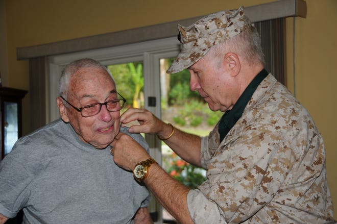 James Merry, left, received a special pin in 2015 from George Wanberg for his military service in the U.S. Navy. He was honored along with his 100-year-old father and brother. [DAILY COMMERCIAL FILE]