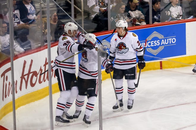 A trio of IceHog players celebrate one of Rockford's goals during a 4-2 win over Manitoba in Friday's Game 1 of the second round of the AHL playoffs. [PHOTO PROVIDED BY THE ROCKFORD ICEHOGS]