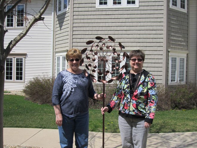 Muriel Freeman (left) and Marsha Moore (right) are donating a wind spinner in memory of their mother, Trudy Pilcher, who was a resident at Courtyard Estates of Canton.