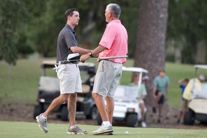 Dillon Humphrey, left, congratulates Mike Riley after his former high school coach won his sixth Sherman Invitational on Sunday at Panama Country Club. [JOSHUA BOUCHER/THE NEWS HERALD]