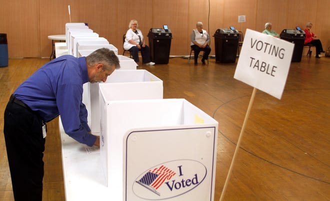 Chris Gribben casts his ballot at the Mozelle Hall voting precinct soon after as the polls opened at 6:30 am Tuesday.
