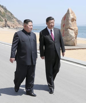 In this photo taken between May 7 and 8, 2018 released by Xinhua News Agency, Chinese President Xi Jinping, right, walks with North Korean leader Kim Jong Un during a meeting in Dalian in northeastern China's Liaoning Province. (Ju Peng/Xinhua via AP)