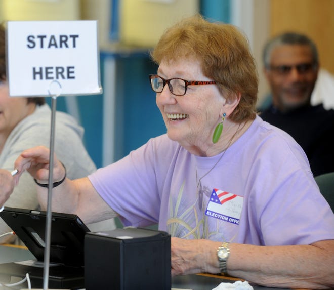 Poll worker, Matha Hilborn checks in a voters at the polling station at Green High School Tuesday, May 8, 2018. (CantonRep.com / Julie Vennitti)