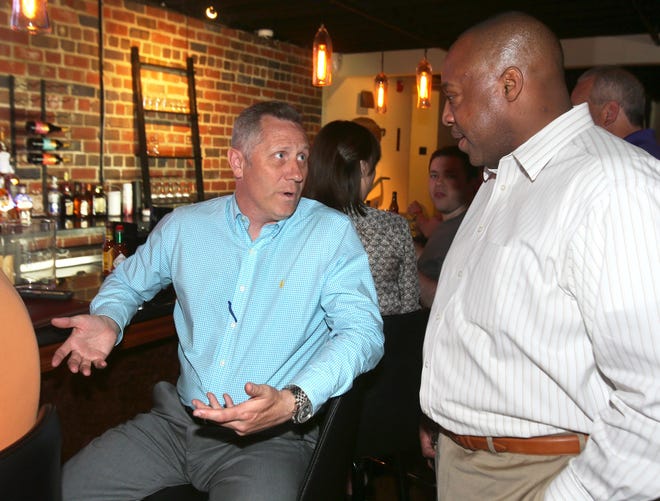 Don Angus (left), director of planning for the city of Canton, speaks with Fonda Williams, deputy mayor of Canton, while watching primary election returns at Street Side in Canton. (CantonRep.com / Scott Heckel)
