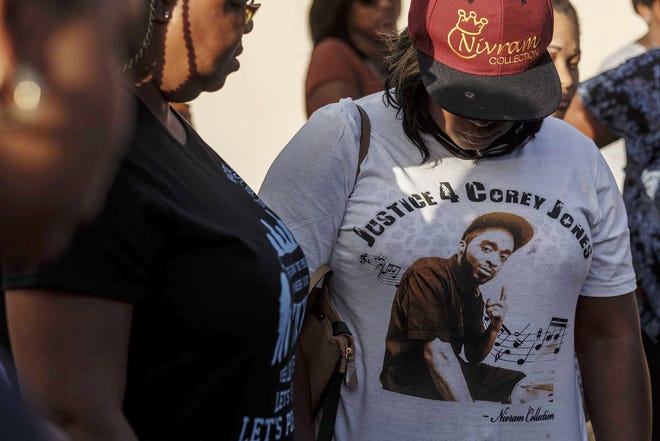 In this Oct. 20, 2015 file photo, friends and family of Corey Jones, seen on the t-shirt, attend a news conference led by Bishop Sylvester Banks, Sr., grandfather of Jones, outside Bible Church of God in Boynton Beach. [Thomas Cordy/Palm Beach Post via AP, File]