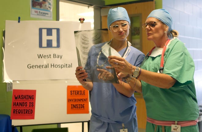 Ashley Champagne looks over an X-ray with Lori Daniel on Monday at West Bay Elementary. [PATTI BLAKE/THE NEWS HERALD]