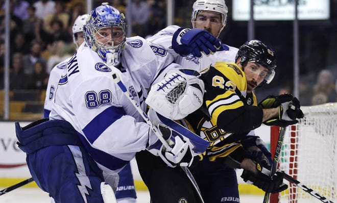 Tampa Bay goaltender Andrei Vasilevskiy tangles with Bruins left wing Brad Marchand during their playoff series. [Charles Krupa/AP]