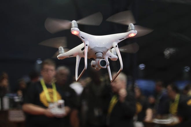In this Jan. 5, 2017, file photo, an exhibitor demonstrates a drone flight at CES International in Las Vegas. On Wednesday, May 9, 2018, federal transportation officials announced 10 sites for a three-year drone program aimed at increasing government and commercial use of unmanned aircraft. The sites are located in Oklahoma, California, Nevada, North Dakota, North Carolina, Kansas, Alaska, Virginia, Tennessee and Florida. (AP Photo/Jae C. Hong, File)