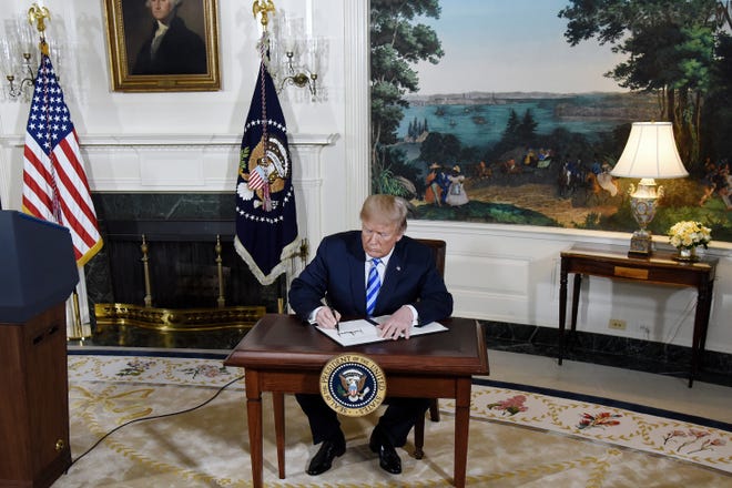 President Donald Trump signs a security memorandum after speaking Tuesday about the Iran nuclear deal, also known as the Joint Comprehensive Plan of Action, during an event in the Diplomatic Room of the White House. Trump withdrew the United States from the agreement. [Olivier Douliery/Abaca Press/TNS]