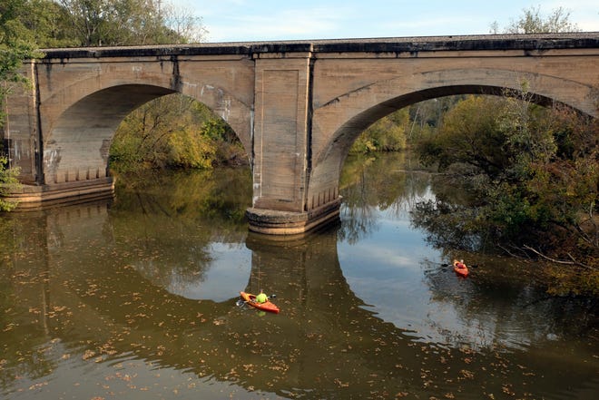 Kayakers paddle under the Norfolk Southern Railroad trestle in Cramerton, which will figure heavily into a 5k road race Saturday as part of the Goat Island Games. [Special to The Gazette]