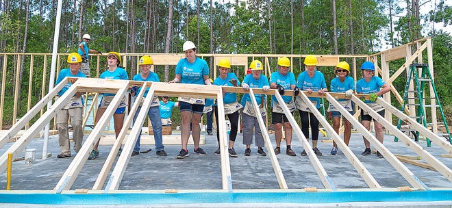 Women work together to raise a section of a wall they built for a Habitat for Humanity of St. Augustine/St. Johns County home under construction in the Flagler Estates community in southern St. Johns County on Wednesday. The women are working on the home during Habitat's annual National Women Build Week, where women across the country come together to work on Habitat homes. The home being constructed for county resident Ricardo Torres will be finished this summer. [PETER WILLOTT/THE RECORD]