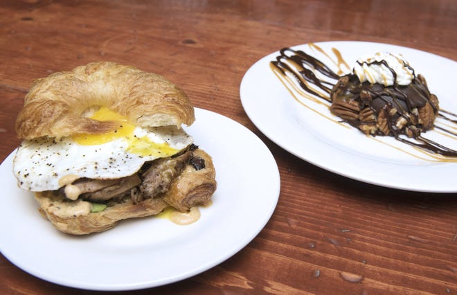 Dessert First Bistro's Boulangerie Pork Croissant, loaded with egg, Swiss cheese, slow-roasted pork, avocado and house-made remoulade, is served alongside its decadent Chocolate Turtle dessert. [CHRISTINA KELSO/THE RECORD]