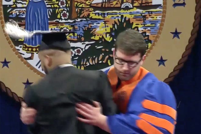 This image from UF video of the commencement ceremony beginning 2 p.m. Saturday shows an usher grabbing a student who was dancing after being announced at the O'Connell Center ceremony.