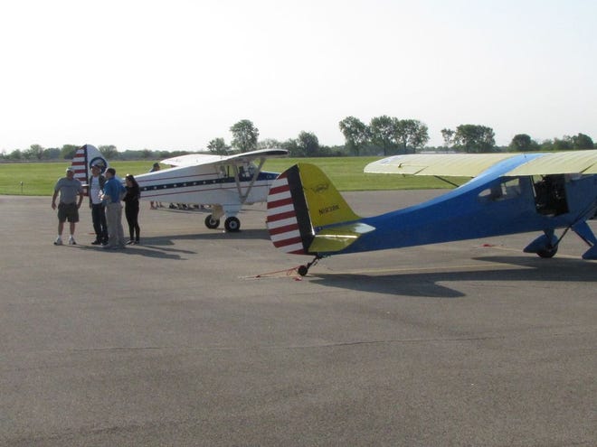 At a previous year's Fly In-Drive In event, a group of people chat while taking a look at different planes. This year's Fly In will be next Sunday, May 20 at the Canton Ingersoll Airport