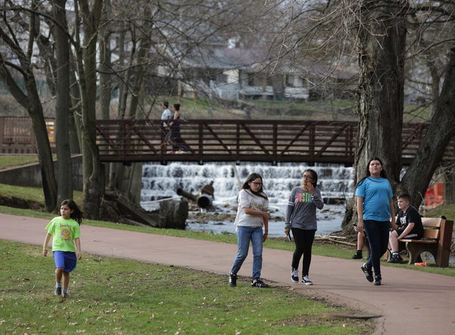 People walk the track on a recent nice day at Resevoir Park in Massillon. The area offers a variety of parks and trails. (IndeOnline.com/ Kevin Whitlock)
