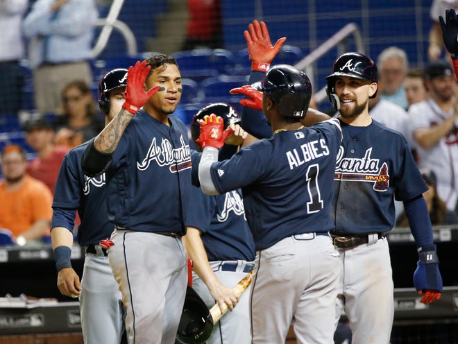 Atlanta Braves' Ozzie Albies (1) celebrates with teammates after hitting a grand slam, scoring Preston Tucker, left rear, Johan Camargo, second from left, and Ender Inciarte, right, during the sixth inning of a baseball game against the Miami Marlins, Thursday, May 10, 2018, in Miami. (AP Photo/Wilfredo Lee)