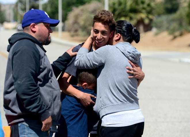 Jennifer Monpano hugs her son Ruben Murillo-Villa, 16, as the family was reunited outside Highland High School in Palmdale after Sheriff took the school off lockdown on Friday, May 11, 2018. A 14-year-old used a rifle to shoot a classmate in the arm Friday at their high school in California and dumped the gun in the desert before he was caught in a shopping center, authorities said. (Dean Musgrove/Los Angeles Daily News/SCNG via AP)