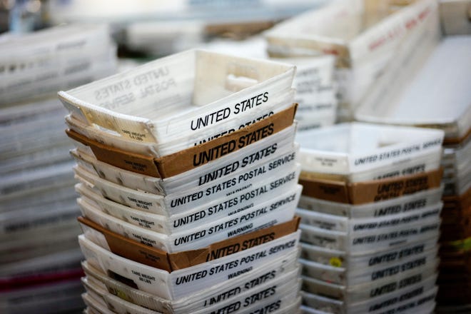 FILE- In this Dec. 14, 2017, file photo, boxes for sorted mail are stacked at the main post office in Omaha, Neb. The U.S. Postal Service is reporting another quarterly loss after an unrelenting decline in mail volume and costs of its health care and pension obligations overcame strong gains in package deliveries. (AP Photo/Nati Harnik, File)