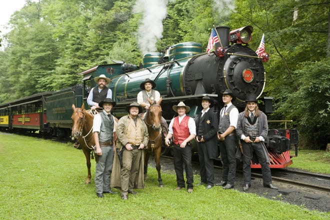 The cowboys of Tweetsie Railroad stand with one of the steam locomotives at the park in Blowing Rock. [Tweetsie Railroad photo]
