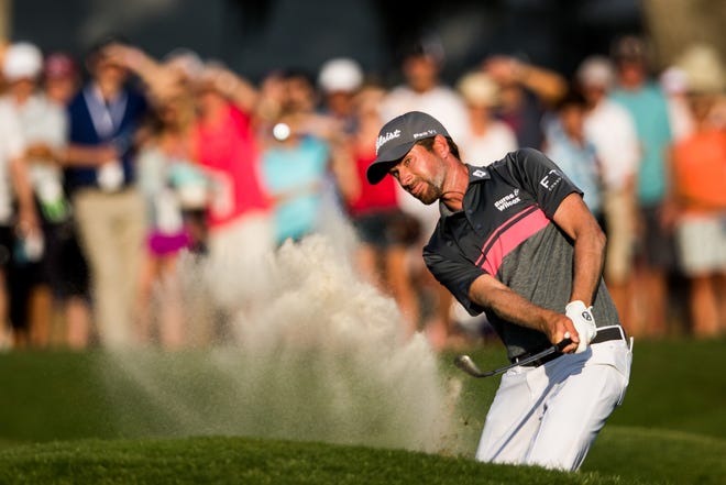 Webb Simpson hits out of the 18th bunker during the third round of The Players Championship on Saturday at TPC Sawgrass. [JAMES GILBERT/CORRESPONDENT]