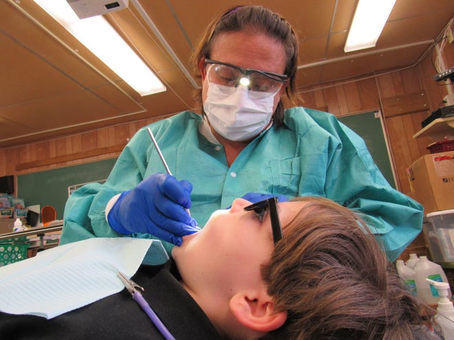 Inside a classroom at Read-Pattillo Elementary School in New Smyrna Beach, dental hygienist Danielle Lindemeyer exams Flynn Hemingway's teeth as part of the Department of Health in Volusia County's Preventive Dental Program offered in Volusia County schools. Photo provided