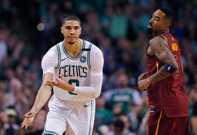 Boston Celtics forward Jayson Tatum (0) celebrates his three-point basket as Cleveland Cavaliers guard JR Smith (5) looks on during the second quarter of Game 1 of the NBA basketball Eastern Conference Finals, Sunday, May 13, 2018, in Boston. (AP Photo/Michael Dwyer)