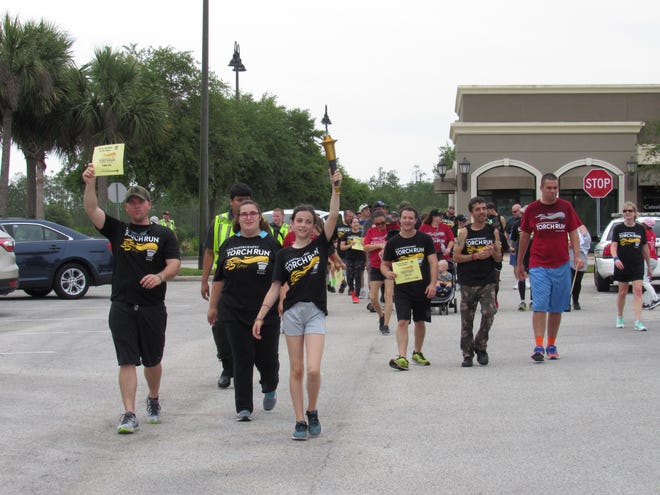 Participants in the 2018 Law Enforcement Torch Run for Special Olympics head back to the Publix on Belle Terre Parkway in Palm Coast to celebrate the trek on Saturday. [News-Tribune photos/Danielle Anderson]