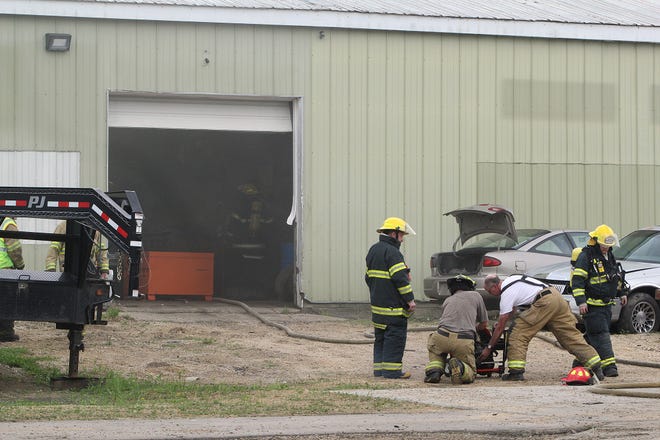 Firefighters from Freeport Rural use a fan to draw smoke from a building after extinguishing a fire on Monday, May 14, 2018, at Mowery's Auto Parts salvage yard in Freeport. [JANE LETHLEAN/THE JOURNAL-STANDARD]
