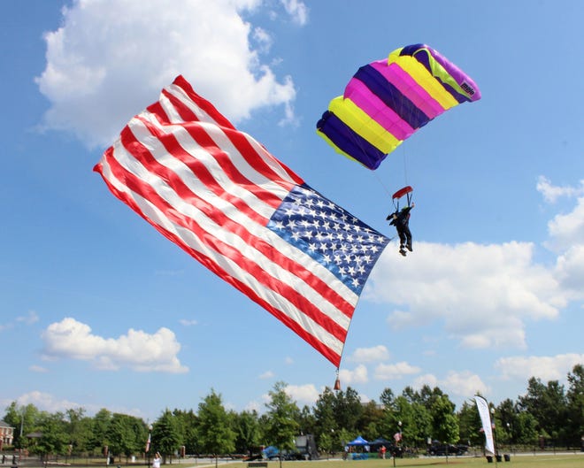 A skydiver flies into Evans Towne Center Park with the American flag to wow the Thunder Over Evans crowd. [File/The Augusta Chronicle]