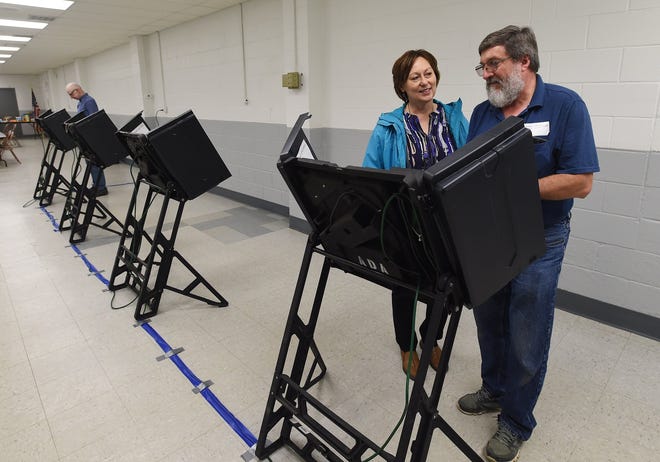 Sue Hammond, 62, of Greenfield Township, is assisted by Frank Eret, machine operator, while voting at the Greenfield Township Fire Hall in the May 15 municipal primary. [JACK HANRAHAN/ERIE TIMES-NEWS]