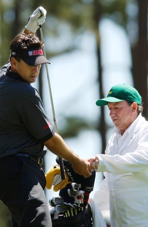 Ben Curtis (left), chooses a club with the help of his caddie and former Kent State coach Herb Page during practice for The Masters in 2004.