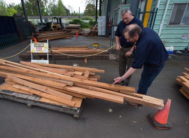 Dan Buckwald and Phil Marvin (right) of Veterans Legacy Oregon look through reclaimed wood from the Willamette Stationers building that they will use for construction projects at Camp Alma, an under construction forest camp for veterans. [Brian Davies/The Register-Guard] - registerguard.com