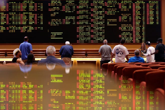 People line up to place bets in the sports book at the South Point hotel-casino, Monday, May 14, 2018, in Las Vegas. The Supreme Court on Monday gave its go-ahead for states to allow gambling on sports across the nation, striking down a federal law that barred betting on football, basketball, baseball and other sports in most states. (AP Photo/John Locher)